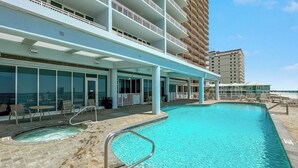 A pool area with a hot tub, lounge chairs, and a covered seating area. - BEACHFRONT, LOW DENSITY CONDO, CORNER UNIT, CLOSE TO RESTAURANTS - The Colonnades 703 (Gulf Shores)