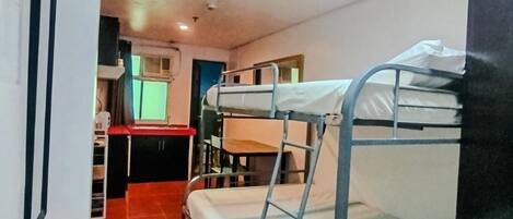 Un dormitorio con literas, un escritorio y una silla.