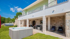A two-story house with a stone exterior, a hot tub, and outdoor seating. - Stunning home in Svib with house a panoramic view (Svib)