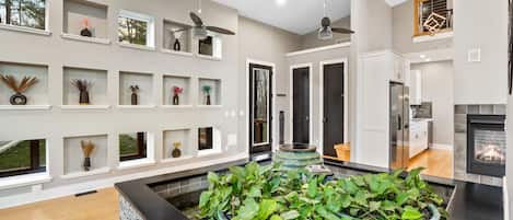 A modern kitchen with a central island, built-in cabinets, and a fireplace.