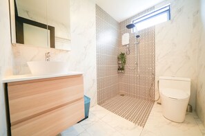 Familie suite | Badkamer | Een douche, een regendouche, een haardroger, een bidet