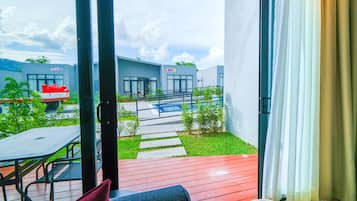 Un patio al aire libre con terraza de madera, un conjunto de asientos y vistas a un edificio moderno con un cartel.