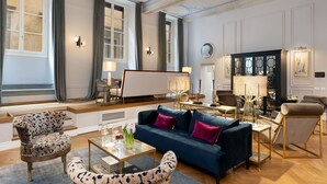 A spacious living room with a blue sofa, patterned armchairs, and a coffee table. - Lovely apartment for 10 people with A/C, WIFI, hot tub, TV and balcony (Florence)