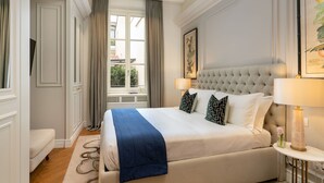 A hotel room with a large bed, two bedside lamps, a window with curtains, and a framed picture on the wall. - Lovely apartment for 10 people with A/C, WIFI, hot tub, TV and balcony (Florence)