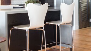 A modern kitchen with a black and white color scheme, stainless steel appliances, and a white island with bar stools. - Spacious Loft, 2 Blocks from Broadway! (Loft 302) (Nashville)