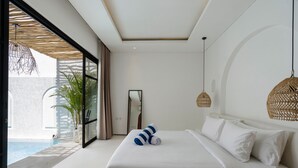 Een moderne hotelkamer met een groot bed, een zithoekje, een groot raam en uitzicht op een zwembad.