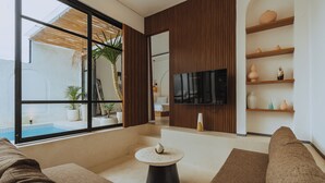 Een moderne woonkamer met een groot raam, een flatscreen televisie en een houten accentmuur.