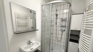 A modern bathroom with a glass-enclosed shower, a white sink, and a mirror above it. - 2 Bed Flat - Sleeps 4 - Pets - Parking - Wifi (Villingen-Schwenningen)