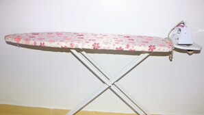 An ironing board with a floral pattern and an iron.