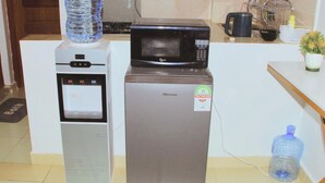 A kitchenette with a water dispenser, a microwave, and a refrigerator.