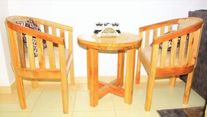 A wooden table with two chairs, a small decorative item on the table, and a tiled floor.