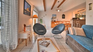 A modern living room with a sofa, two armchairs, a coffee table, and a dining area with a table and chairs. - Les coutures by Interhome (Ile d'Oléron)