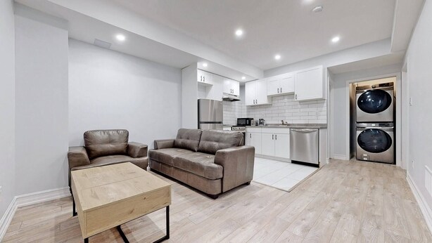 A modern kitchen with white cabinets, stainless steel appliances, and a built-in oven. - Charming 2- Bedroom With Free Parking Space (Whitby)