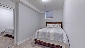 A bedroom with a bed, a window, and a door. - Charming 2- Bedroom With Free Parking Space (Whitby)