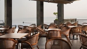 A terrace with wicker furniture and a view of the sea. - Laska Hotel Resort Ciletuh (Girimukti)