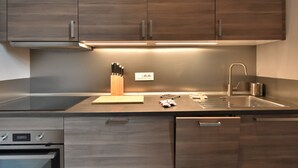 A modern kitchen with wooden cabinets, a stainless steel sink, and a built-in oven. - Gluck Central Station Lofts by Interhome (Milan)