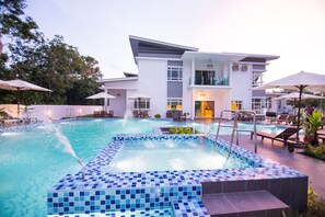 A modern hotel with a swimming pool, lounge chairs, and umbrellas. - The Duyong Dream (Malacca City)