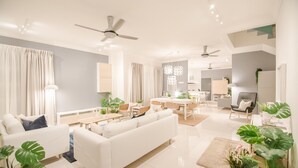 A modern living room with a white sofa, dining area, and kitchen. - The Duyong Dream (Malacca City)
