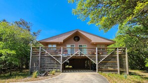 Un bâtiment à deux étages avec une entrée de garage, entouré d’arbres.