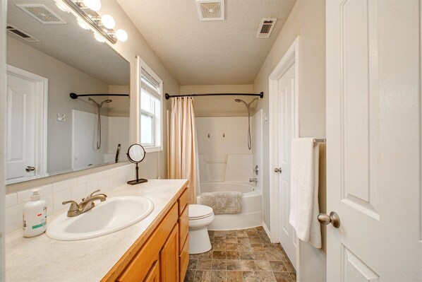 Une salle de bain avec un lavabo, des toilettes et une douche.