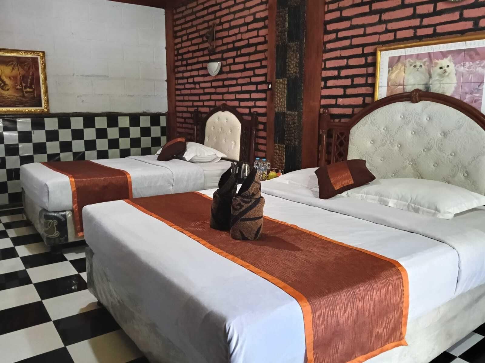 A hotel room with two beds, checkered floor, and a brick wall.