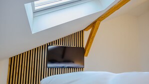 A modern room with a sloped ceiling, a skylight, and a wooden beam structure. - Rezidence Petra Voka 208 by Interhome (Trebon)