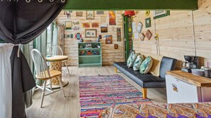 Une pièce chaleureuse avec un mur en bois, un canapé, une petite table et un tapis coloré.