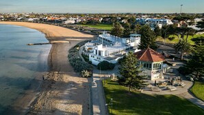 Un hôtel situé sur la côte, avec vue sur la plage, un parking et une pelouse bien entretenue.