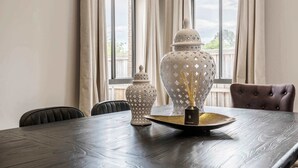 A dining table with a decorative centerpiece, two vases, and a chair.