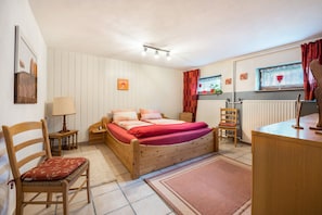 A bedroom with a wooden bed, a chair, a desk, a lamp, and a radiator. - Holiday Home 'Ferienwohnung Loy' with Private Terrace, Private Garden and Wi-Fi (Rastede)