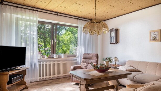 A living room with a television, sofa, table, and a window with curtains. - Holiday Home 'Ferienwohnung Loy' with Private Terrace, Private Garden and Wi-Fi (Rastede)