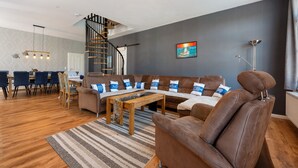 Un salon moderne avec un canapé, une table basse et un escalier.