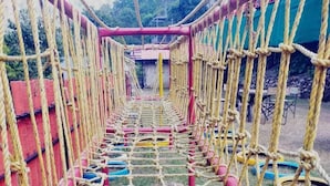 A rope bridge structure with netted sides and a central walkway. - Rudra Adventures (Narendranagar)