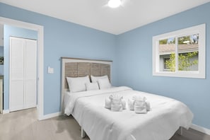 A bedroom with a bed, a window, and a door.