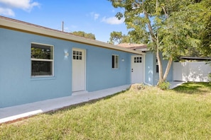 A single-story house with a light blue exterior, a front door, and two windows.