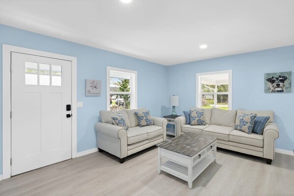 A living room with two sofas, a coffee table, and a door.