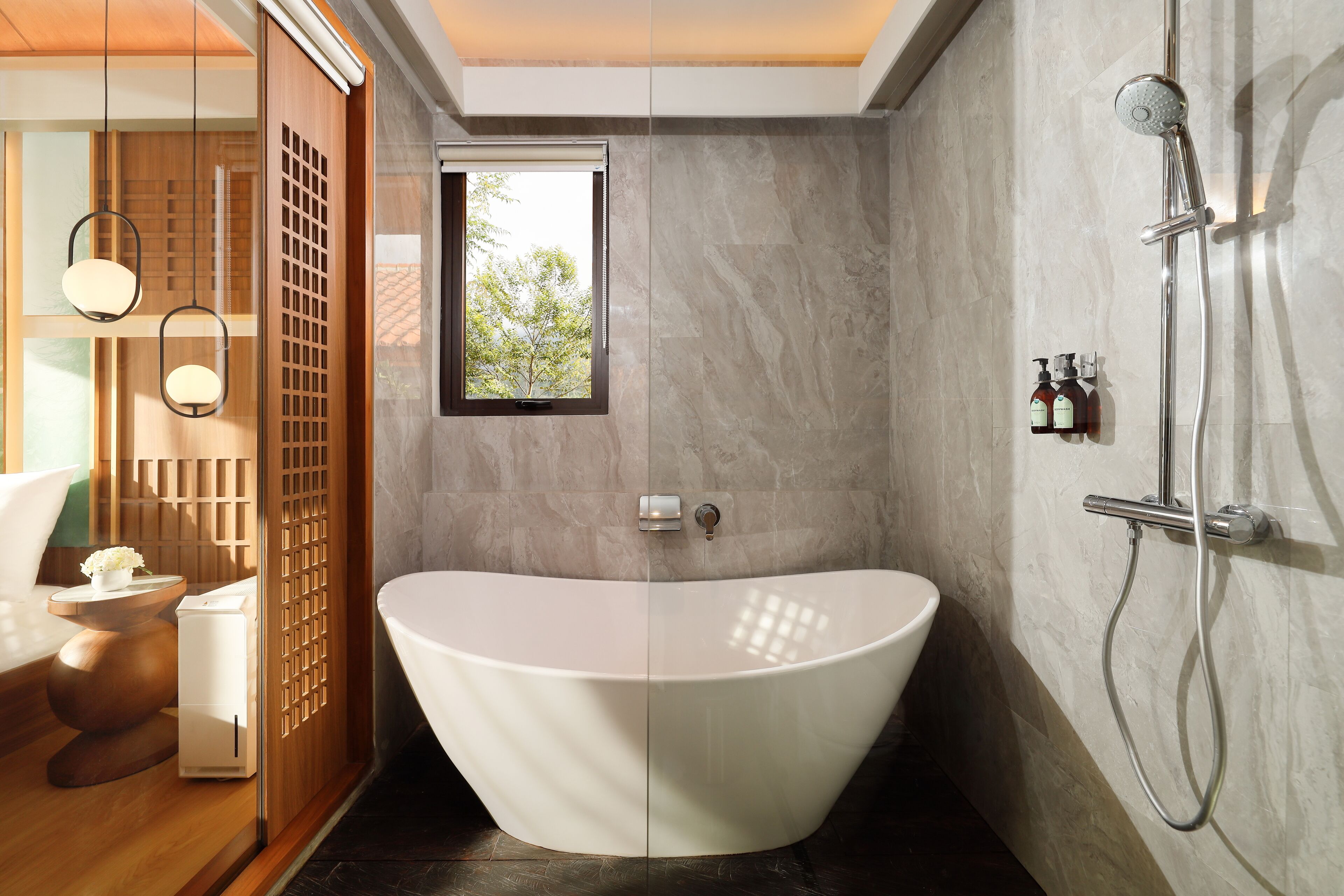 Un baño moderno con una bañera independiente, ducha y ventana que proporciona luz natural.