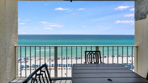 A balcony with a view of the beach and ocean.