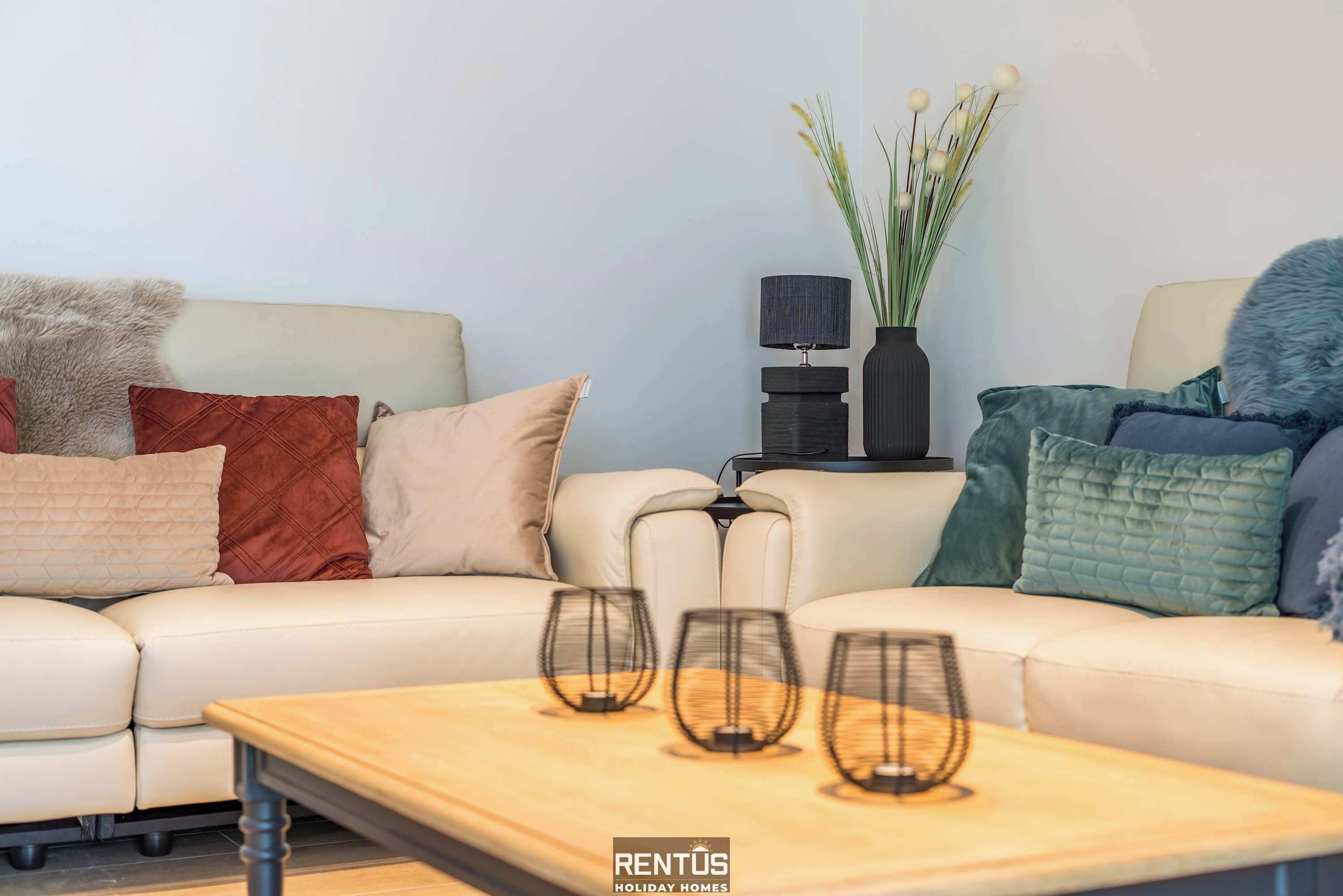 Una sala de estar con sofá, mesa de centro y lámpara.