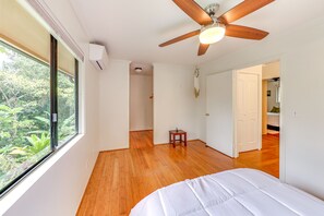A bedroom with a large window, wooden flooring, a ceiling fan, and a bed. - ~ 2 Mi to Beach: Princeville Condo w/ Private Deck (Princeville)