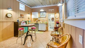 A compact kitchen with wooden cabinets, a dining area with stools, and a small bar area. - 5 Mi to Beach: Inglis Studio w/ Patio & Grill! (Inglis)