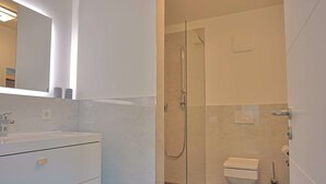 A modern bathroom with a glass-enclosed shower, a white sink, and a toilet. - Villa Baltic Star Ferienwohnung 10 (Börgerende-Rethwisch)