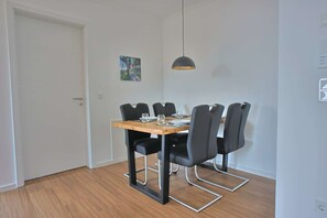 Enjoy meals in this stylish dining area with a wooden table and six chairs, featuring a pendant light and a personal touch of artwork.