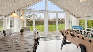 A spacious indoor area with a foosball table, a sofa, and a table with glasses. - "Chrisse" - 250m from the sea by Interhome (Otterup)