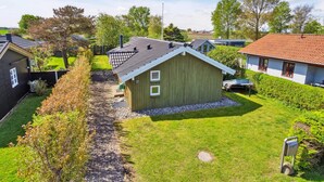A residential area with a green house, a red-roofed house, and a clear sky. - "Hereth" - 100m from the sea by Interhome (Otterup)