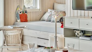 A cozy room with a bed, a small table with a book, a vase, and dice. - "Hereth" - 100m from the sea by Interhome (Otterup)