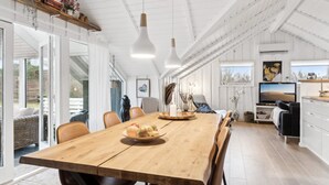 Een ruime keuken met een houten tafel, moderne apparatuur en een groot raam.