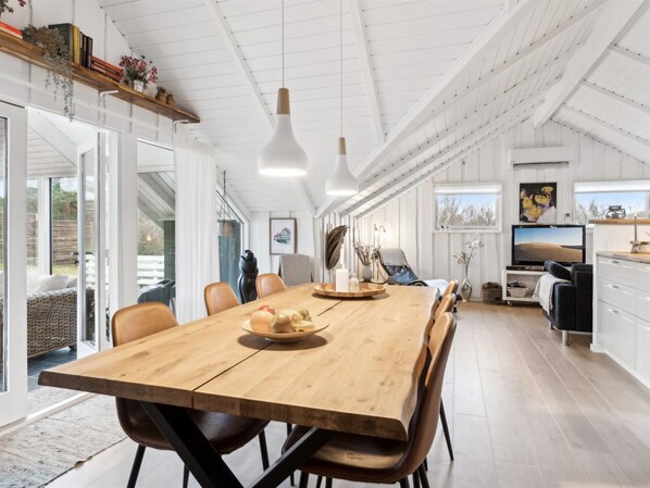 Una cocina amplia con una mesa de madera, electrodomésticos modernos y un ventanal grande.