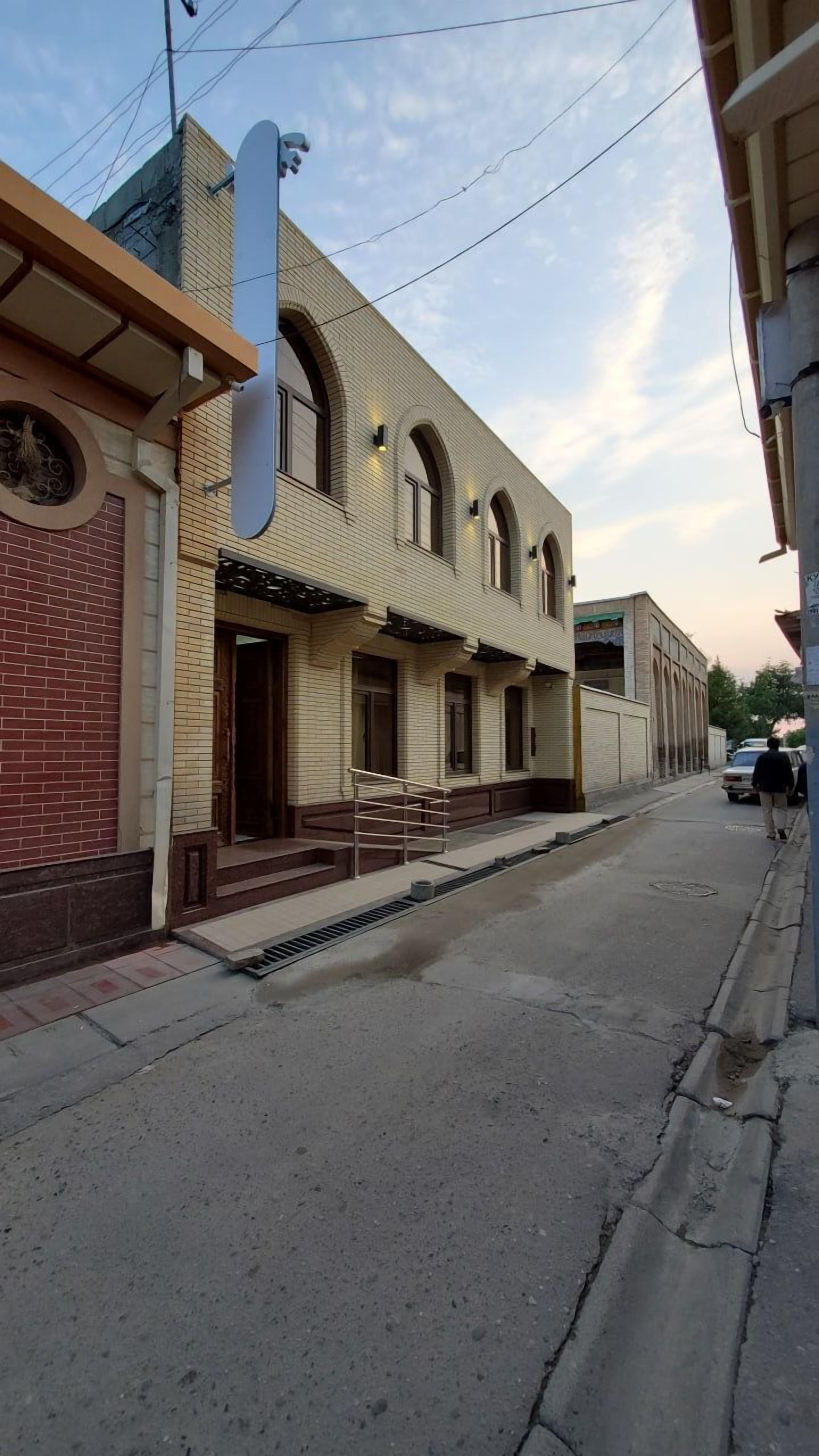 A two-story building with a brick facade and arched windows.