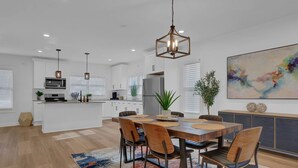 A modern kitchen with white cabinetry, a central island, and pendant lighting. - Atlanta Hamilton House, 7 Beds (Atlanta)